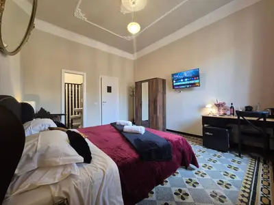 a bedroom with a bed and a desk and a mirror at HEBE Eternity Rooms in Rome