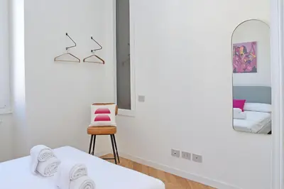 a room with two beds and a chair and a mirror at Scipioni in Rome