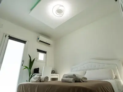 a white bedroom with a bed and a window at Felix Rooms in Rome
