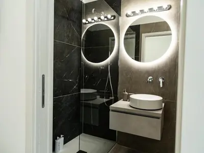 a bathroom with a sink and two mirrors at Felix Rooms in Rome