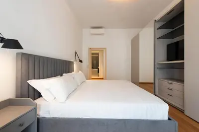 a bedroom with a large white bed and a tv at Vatican Scipioni Apartment in Rome
