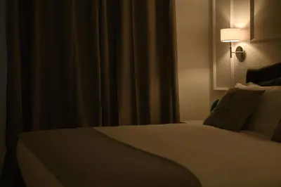 a bedroom with a bed with a lamp and curtains at Domus Ludovica in Rome