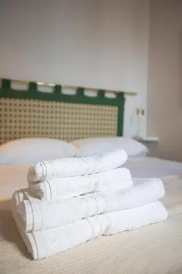 a stack of white towels sitting on a bed at Suite Bormida - Coppedè in Rome