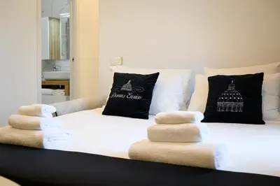 a white bed with pillows and towels on it at Domus Enrico in Rome