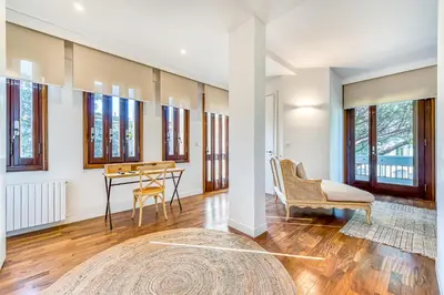 a living room with a table and chairs and windows at Skylife Art Gallery Loft - Riverfront Art Sanctuary in Rome