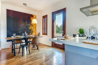 a kitchen with a table with chairs and a dining room at Skylife Art Gallery Loft - Riverfront Art Sanctuary in Rome