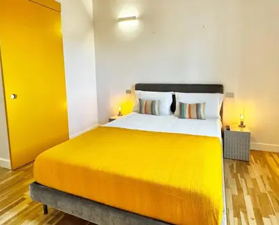 a bedroom with a large bed with a yellow blanket at Vetrina Roma - Stay in Luxury in Rome