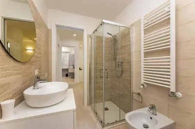 a bathroom with a sink and a glass shower at Vatican Apartment - Betty Home in Rome