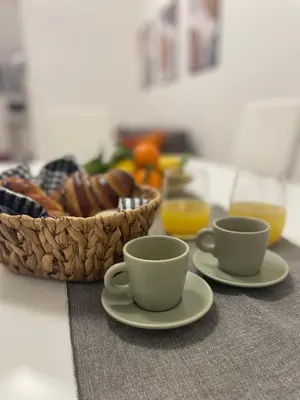 a table with two cups and a basket of bread at Vatican Apartment - Betty Home in Rome