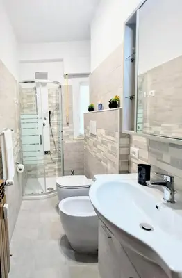 a white bathroom with a toilet and a sink at Cozy apartment near metro A in Rome