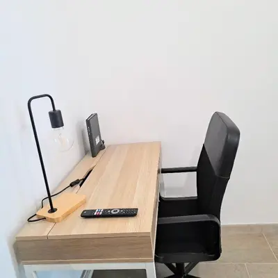 an office desk with a chair and a lamp at Cozy apartment near metro A in Rome
