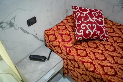 a bed with a red and white pillow and a phone at Affittacamere Tiche in Rome