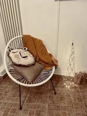a white chair with a blanket on top of it at Leonardo Guest House Roma in Rome