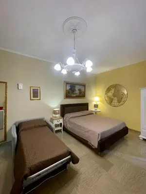 a bedroom with two beds and a chandelier at Barbi's Home- Colli Albani Roma in Rome
