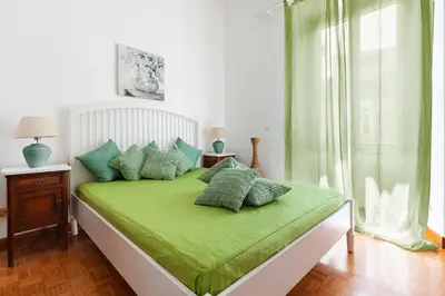 a bedroom with a bed with green sheets and pillows at Spanish Steps Historic Apartment in Rome