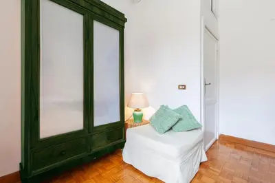 a bedroom with a bed with a green cabinet at Spanish Steps Historic Apartment in Rome