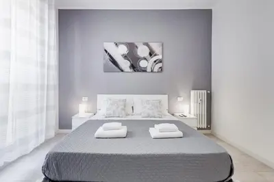 a white bedroom with a large bed with two pillows at Dimora Testaccio in Rome