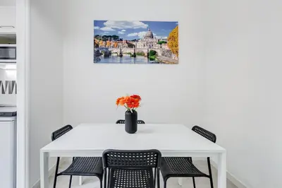 a white table with chairs and a vase with flowers at Dimora Testaccio in Rome