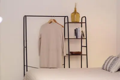 a bedroom with a white shirt on a rack next to a bed at Scipioni Relais in Rome