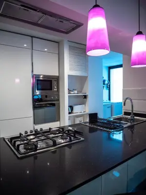 a kitchen with a black counter top with pink lights at Conca D'oro Colors - Metro & WI-FI in Rome