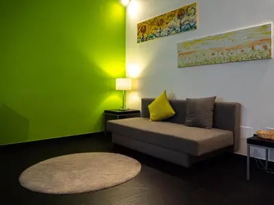 a living room with a couch and a green wall at Conca D'oro Colors - Metro & WI-FI in Rome