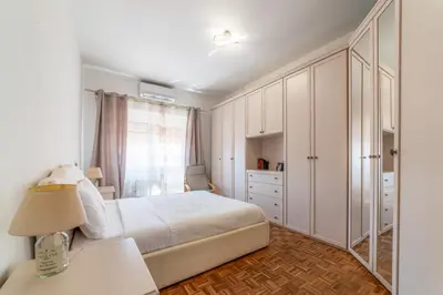 a white bedroom with a bed and a dresser at Giorgia Flat - Tiburtina Train Station - Wi-Fi in Rome