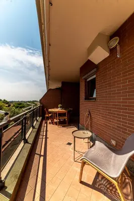 a patio with a table and a chair on a balcony at La Terrazza sul Parco Appartamento per famiglie, Vaticano, Metro A in Rome