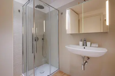 a bathroom with a sink and a glass shower at Corte Trastevere Living in Rome