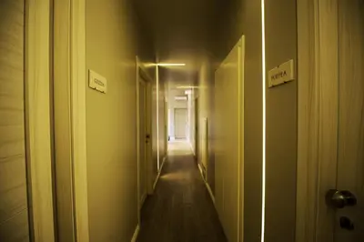 a hallway with a long corridor with signs on the walls at The Roman Empire Guesthouse in Rome