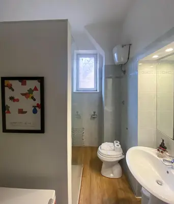 a white bathroom with a toilet and a sink at JHHIT - In the heart of Rome near the Colosseum in Rome