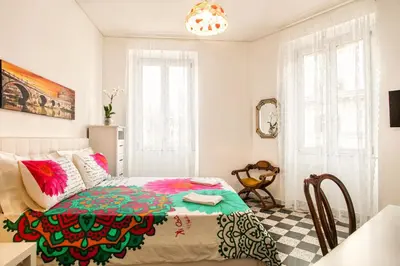 a bedroom with a bed with pink flowers on it at Vatica B&B Roma in Rome