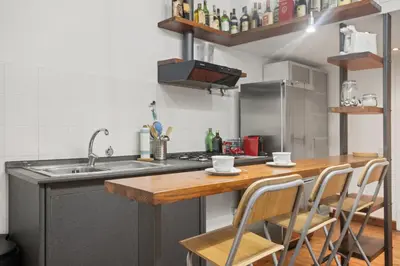 a kitchen with a sink and a counter with chairs at Pretorius Design Loft - Near Termini Station by RHR in Rome