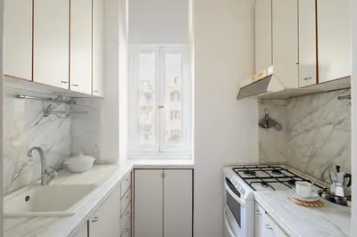 a white kitchen with a sink and a stove at Casa Mandes Spanish Steps in Rome