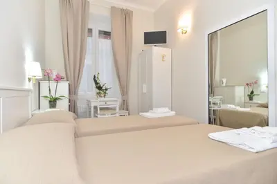 a hotel room with two beds and a bathroom at Romebest in Rome