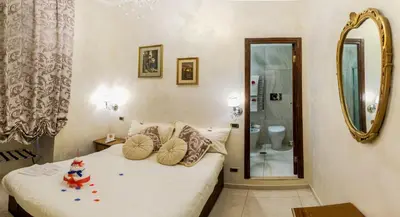 a small bedroom with a bed and a mirror at B&B Roma Royal Residence in Rome