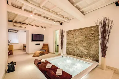 a hot tub in a room with a brick wall at YH Suite in Rome