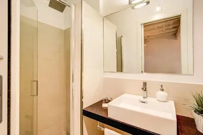 a white bathroom with a sink and a mirror at YH Suite in Rome