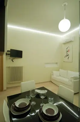 a living room with a table with plates and wine glasses at Silenzioso Monolocale in Zona Parioli in Rome