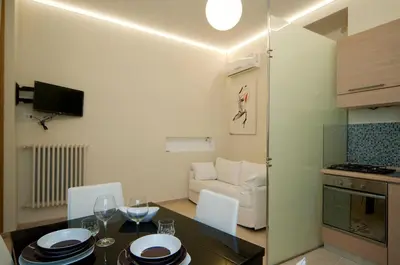 a kitchen and a living room with a table and chairs at Silenzioso Monolocale in Zona Parioli in Rome