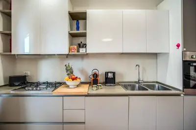 a kitchen with white cabinets and a sink at Homely - spacious Apt in gianicolo district in Rome