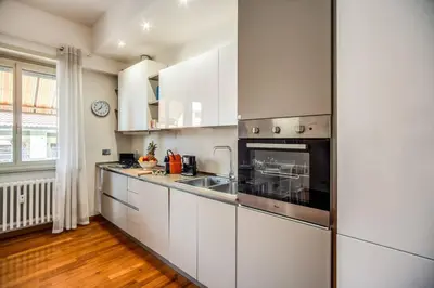 a kitchen with white cabinets and a stove top oven at Homely - spacious Apt in gianicolo district in Rome