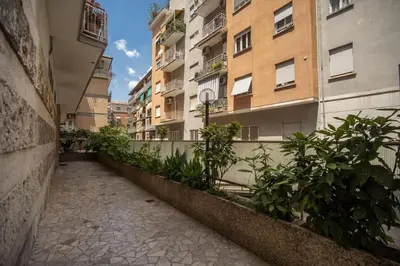 an empty alley in a city with tall buildings at Homely - spacious Apt in gianicolo district in Rome