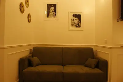 a couch in a room with two pictures on the wall at Don Raffaele Resort Roma - Guest House in Trastevere