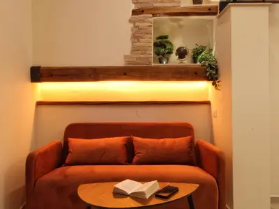 a couch with a table with a book on it at Domus Grottae at Campo de fiori in Rome
