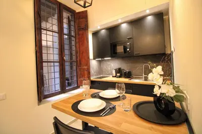 a kitchen with a wooden table with plates and wine glasses at Domus Grottae at Campo de fiori in Rome