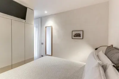 a bedroom with a bed and a television on a wall at Domus Romano Piazza Farnese in Rome