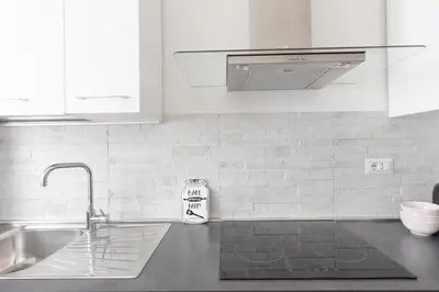 a kitchen with a sink and a counter top with a sign at Luminoso a due passi da Trastevere in Rome