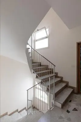 a spiral staircase in a white room with a window at Luminoso a due passi da Trastevere in Rome