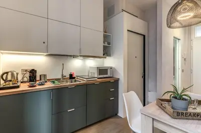 a kitchen with white cabinets and a counter top at Domus Romano Campo de Fiori in Rome