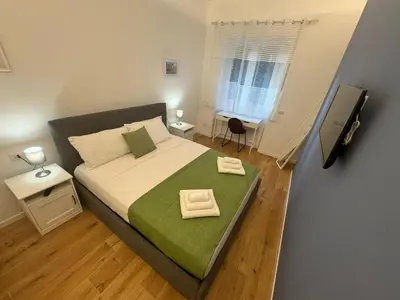 a small bedroom with a bed with a green blanket at Roman Pearl in Portuense in Rome